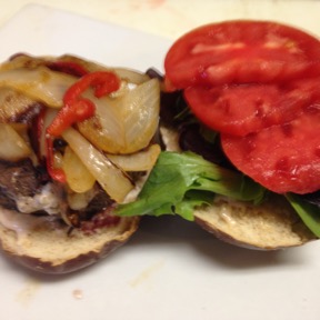 Goat cheese stuffed burger with sauté onion& pepper on pretzel bun